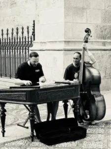 Street musicians playing double bass and dulcimer in black and white urban setting